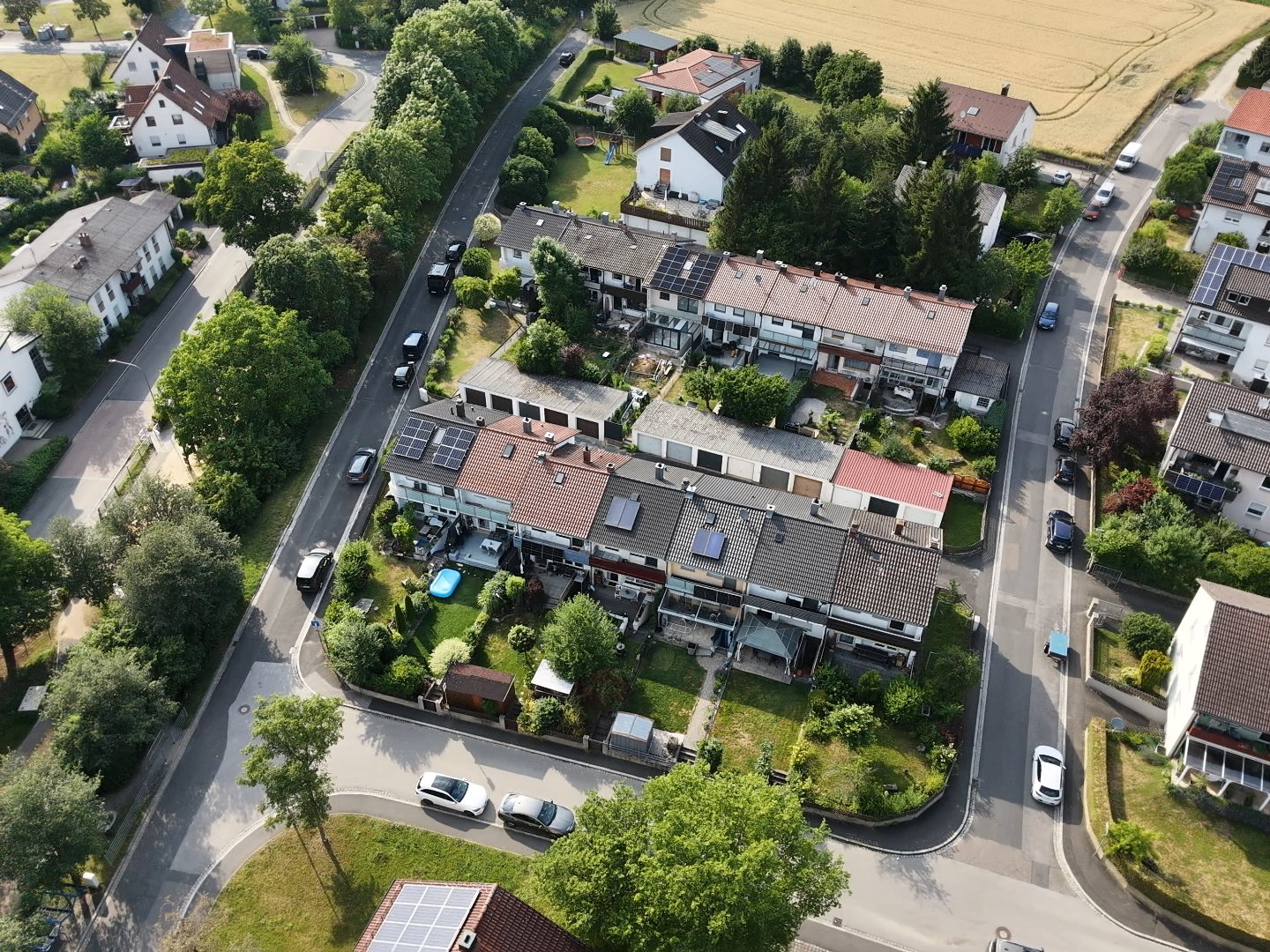 Luftaufnahme einer Reihenhaussiedlung mit Gärten